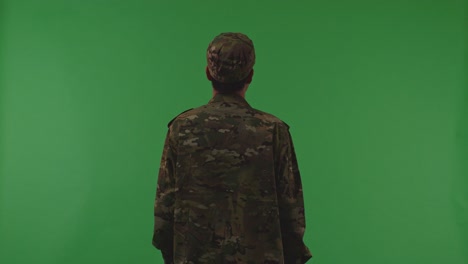 back view of asian male soldier standing and looking around to protects his country from the war on the green screen background