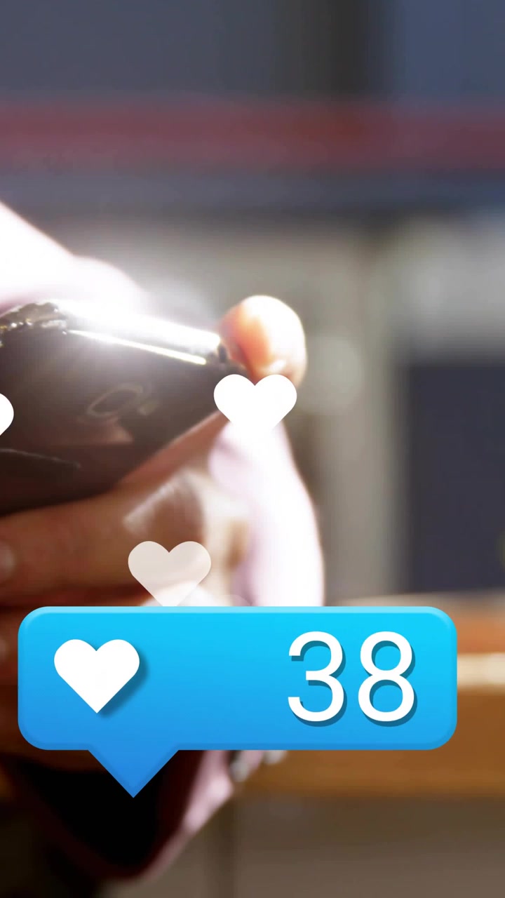 Vertical video: Man holding phone watching new social likes, hearts floating as counter hitting 77