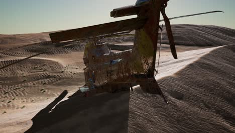 old rusted military helicopter in the desert at sunset