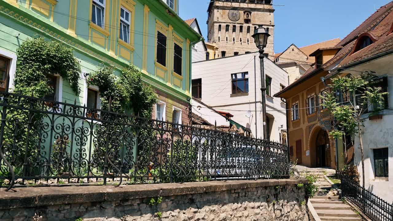 Vista del centro storico di Sighisoara, Romania. Torre dell'orologio, stretta via con edifici antichi