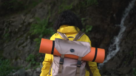 woman hiking in the mountains near a waterfall