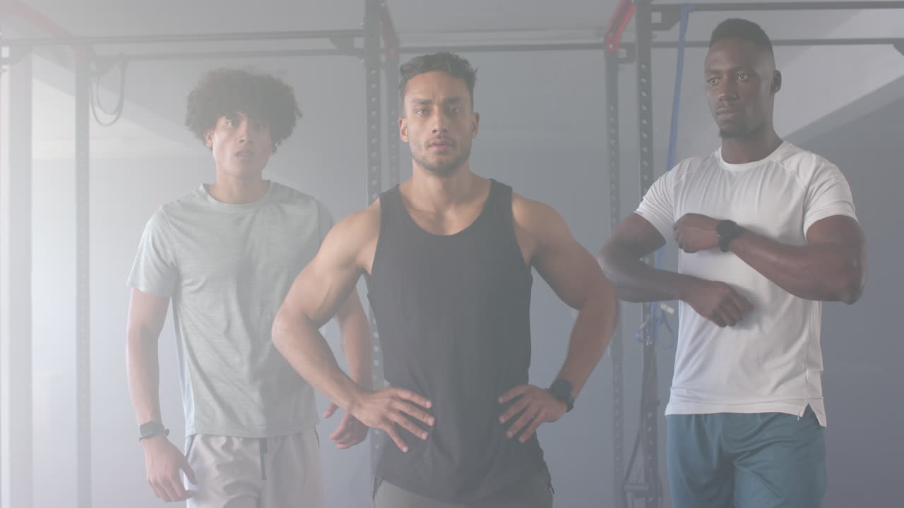 Group of diverse young men training in gym, standing in front of fitness equipment