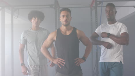 group of diverse young men training in gym, standing in front of fitness equipment