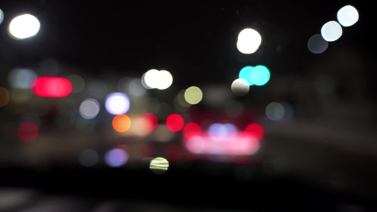 bokeh de automóviles y semáforos por la noche. bokeh de tráfico nocturno de una pequeña ciudad europea. bokeh redondo y colorido que brilla de las luces de los automóviles en el atasco de tráfico en la calle de la ciudad