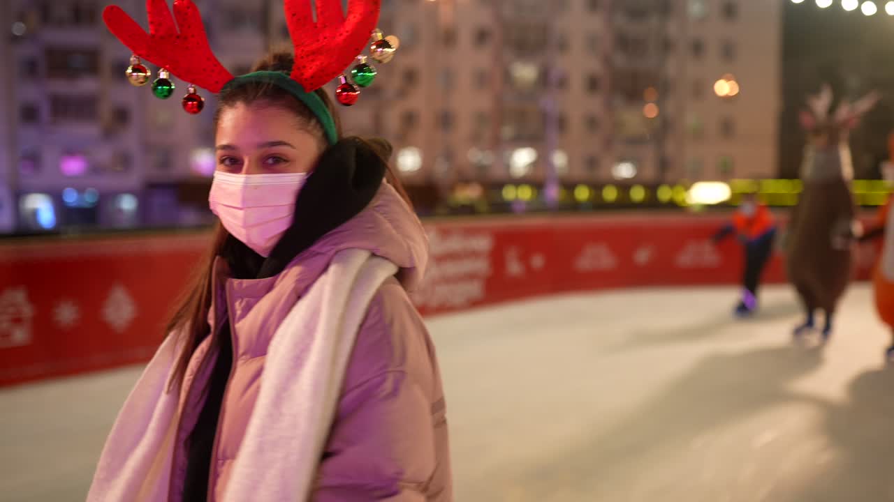 молодая девушка катается на коньках на ночном рождественском рынке