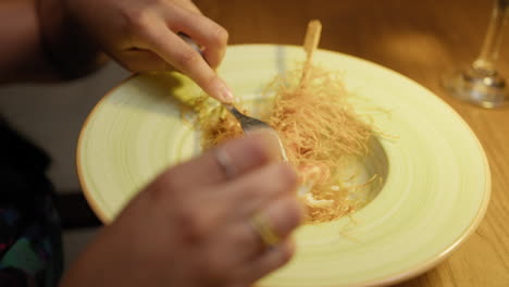 fork removing shrimps from the skewer inside the gourmet dish