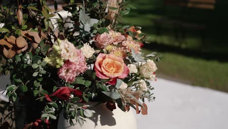 vibrant floral arrangement with roses and greenery in white vase with natural light