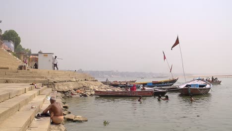 hombre agazapado en los ghats del ganges