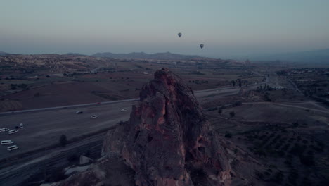 cappadocia's rocky terrain with hot air balloons at sunrise