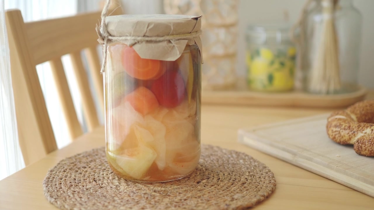 Bocal en verre de légumes marinés maison sur une table en bois