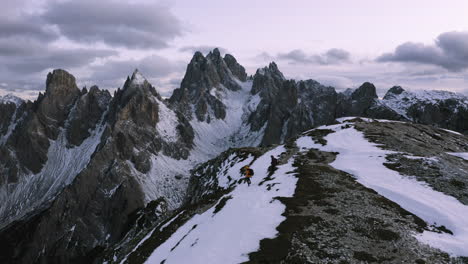 aerial view of hikers at the cadini di misurina viewpoint, winter evening in dolomites, italy