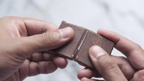 broken chocolate bar in hands