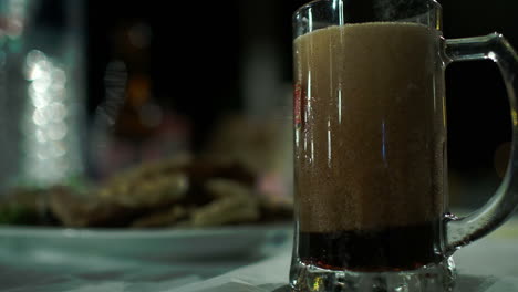 pouring dark beer into glass mug