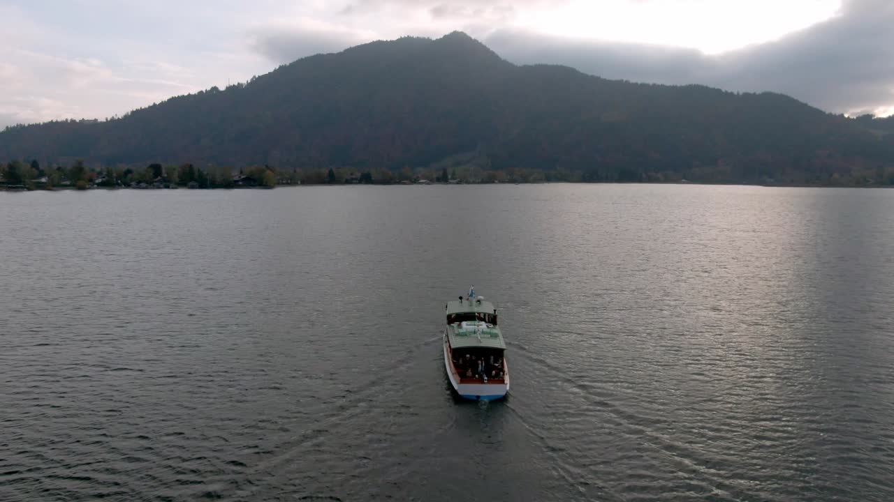 Traghetto con turisti in un lago verso una città lacustre in Germania - Tegernsee, Germania.