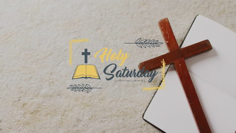 animation of holy saturday text over christian cross and book on grey background