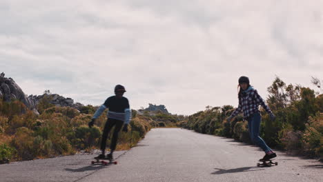 Amigos-Felices-Amigos-De-Longboard-Chocando-Los-Cinco-Montando-Patineta-Juntos-Haciendo-Trucos-En-La-Carretera-Rural-Disfrutando-De-Las-Vacaciones-De-Verano-Patinando-Con-Casco-Protector