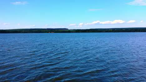 crossing the river and following to the waterfront. sunny day in nature. bank of the river covered with green trees.