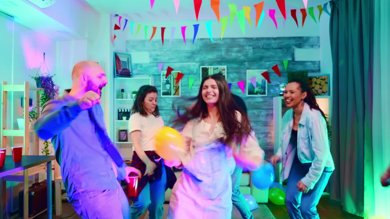 zoom en la toma de la hermosa caucásica bailando con sus amigos en la fiesta con luces de neón