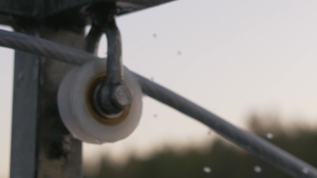 cierre el mecanismo borroso de una rueca giratoria con gotas de agua en cámara lenta cayendo