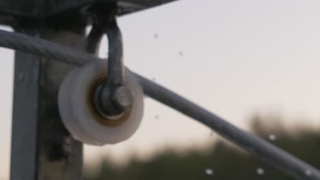 close up blurry mechanism of a rotating spinning wheel with slow motion water drops falling