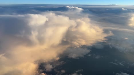 aerial view of some cumulonimbus clouds taken from a jet cockpit during the cruise with nice colors