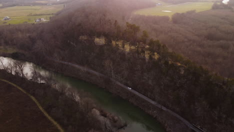aerial view of a river, road, and cliff in a rural landscape