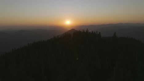 tranquil sunset scene flying over forested peak in gifford pinchot national forest in pacific northwest, washington state.