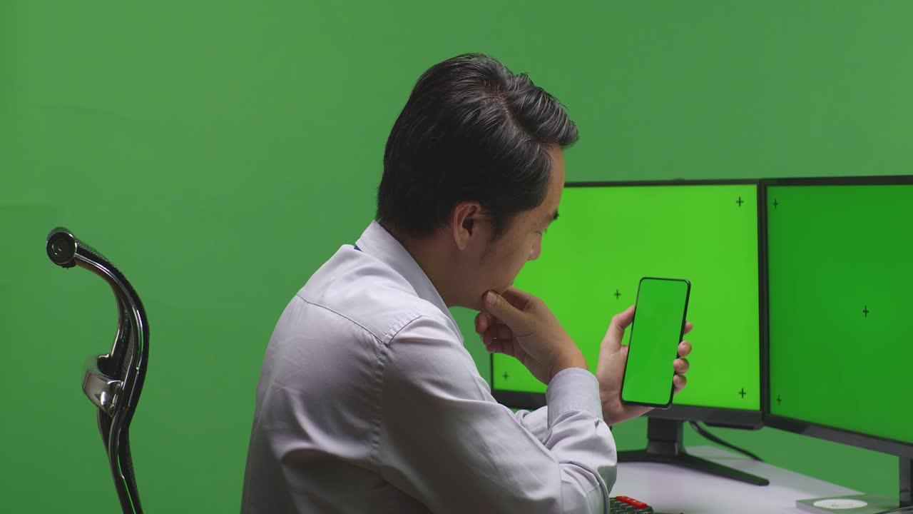 컴퓨터에서 스마트폰을 사용하는 사업가