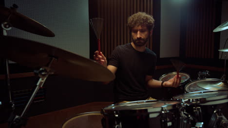 artist hitting drum cymbals in studio. drummer performing solo in concert hall.