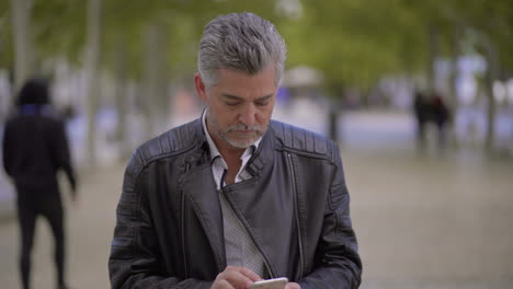 Excited-mature-man-using-smartphone-outdoor