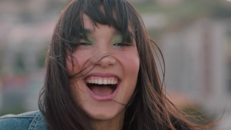 close up portrait happy asian woman on rooftop shaking hair blowing in wind enjoying freedom laughing cheerfuly in urban city