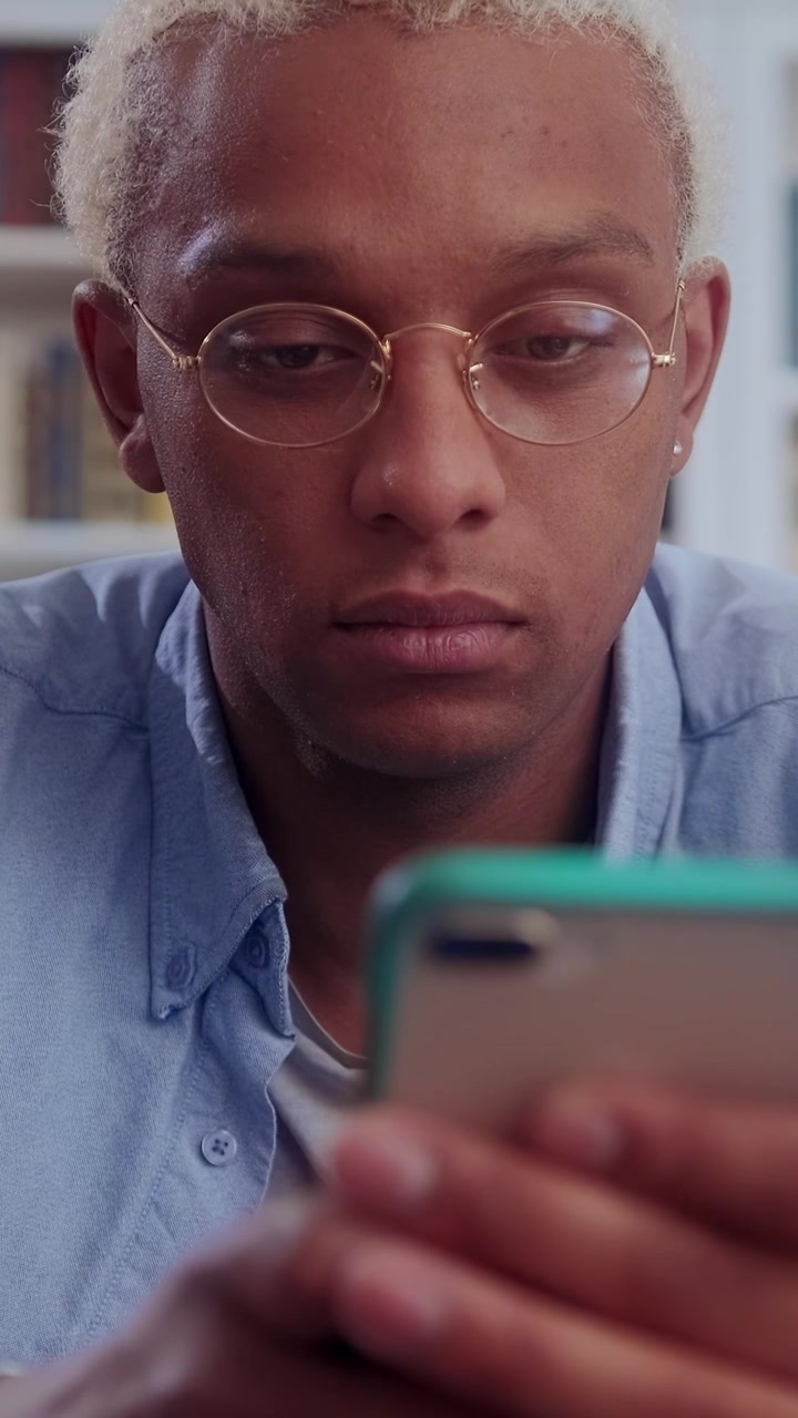 Focused african american man concentrates deeply while typing and scrolling on