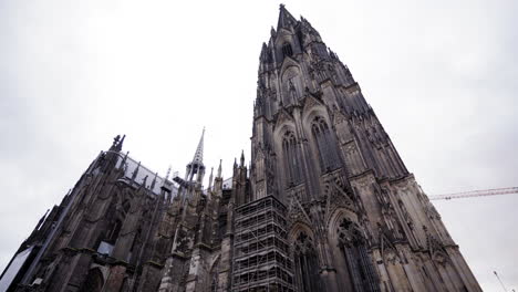 a dramatic view of the iconic cologne cathedral in germany, showcasing its intricate gothic architecture against a cloudy sky. perfect for travel and history projects.
