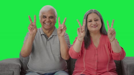 Happy-Indian-old-couple-showing-victory-sign-Green-screen