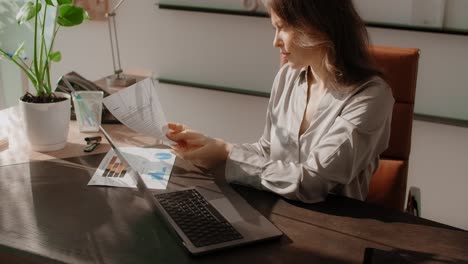 woman reviewing financial documents at her desk