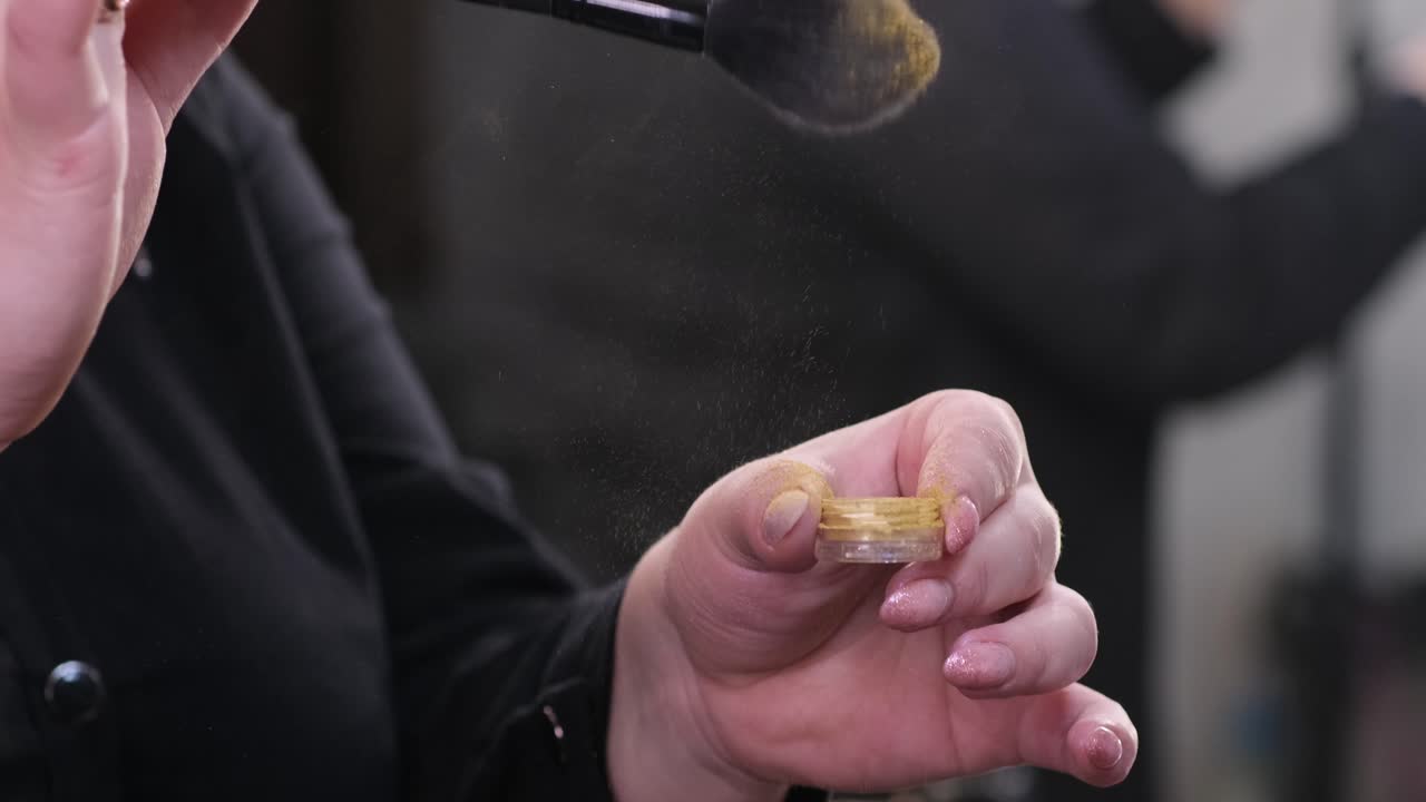 Manicurist ryster pudderet i en skønhedsbutik