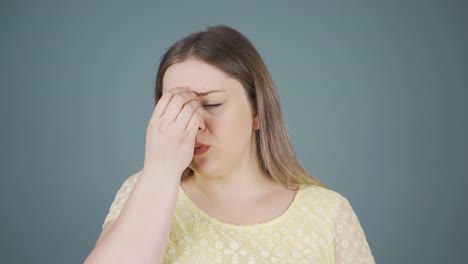 편두통을  ⁇ 고 있는 젊은 여성이 통증을 경험하고 있습니다.