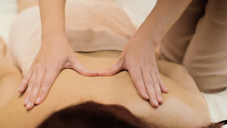 masseuse giving massage to woman