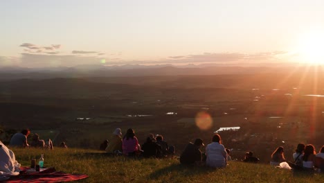 people gather to watch sunset over valley