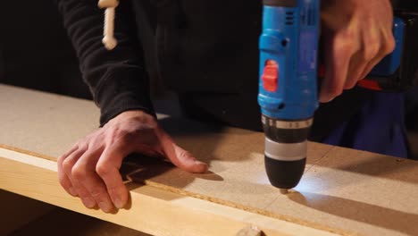 primer plano de alguien usando un taladro para montar piezas de madera