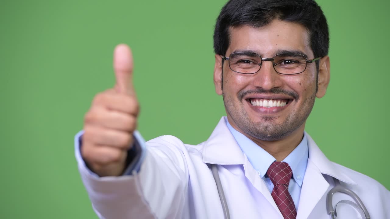 Young handsome Persian man doctor thumbs up