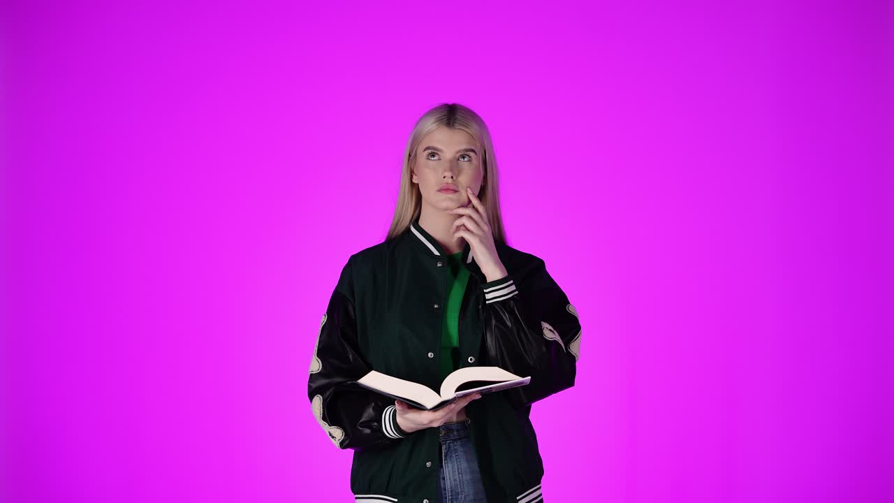 Bella giovane donna che legge un libro, pensa e memorizza la lezione.