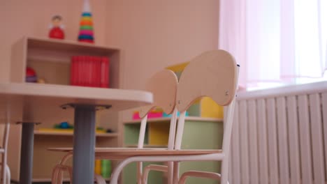 wooden table with small chairs in classroom of kindergarten