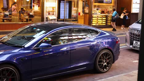 a blue car amidst bustling street activity