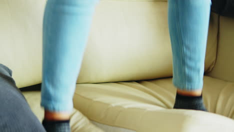 little girl jumping on the couch in living room