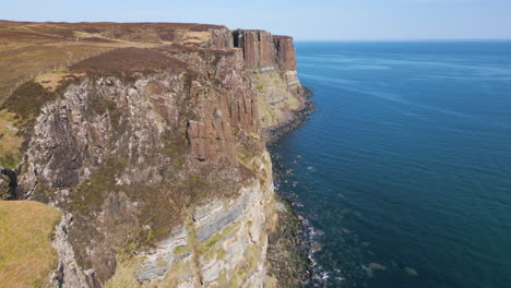 Aerial-flying-over-Kilt-Rock-slope-on-sunny-day,-Isle-of-Skye,-Scotland