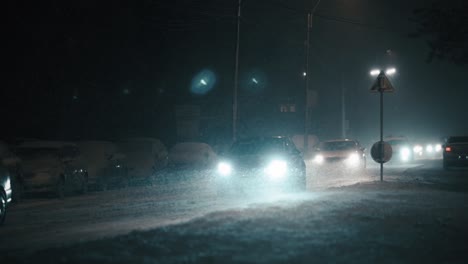 Autos-Conduciendo-En-La-Ciudad-En-Una-Helada-Noche-De-Invierno-Durante-Una-Ventisca,-En-Cámara-Súper-Lenta