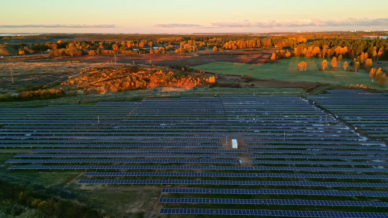 Aerial view of solar panels at sunrise with autumn landscape around