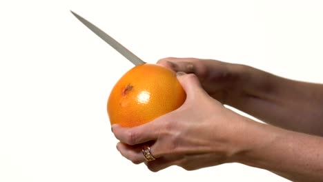 la chica corta un cuchillo para pelar el pomelo.