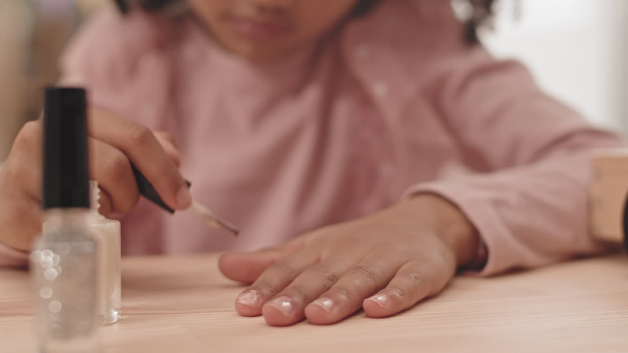 Unrecognizable Child Painting Nails with Polish
